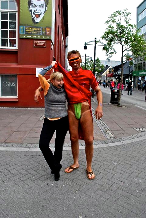 Man in red silk dress and green thong in  Reykjavik Icleand